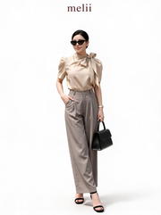 MELII warm beige bow-neck blouse with charcoal-grey wide-leg trousers, studio model view